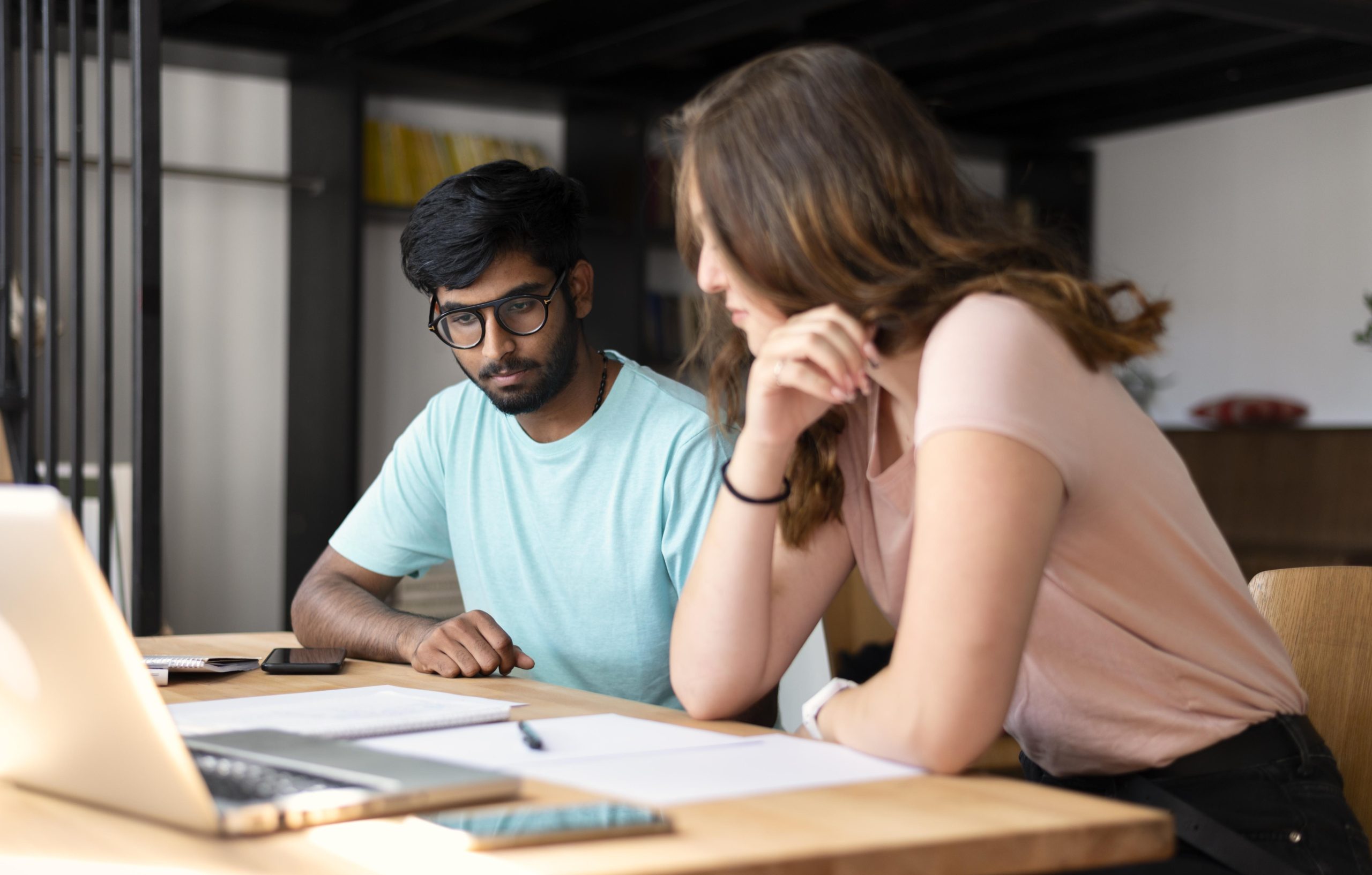 A focused student studying for the UGC NET exam with books and a laptop, highlighting dedication to academic preparation.