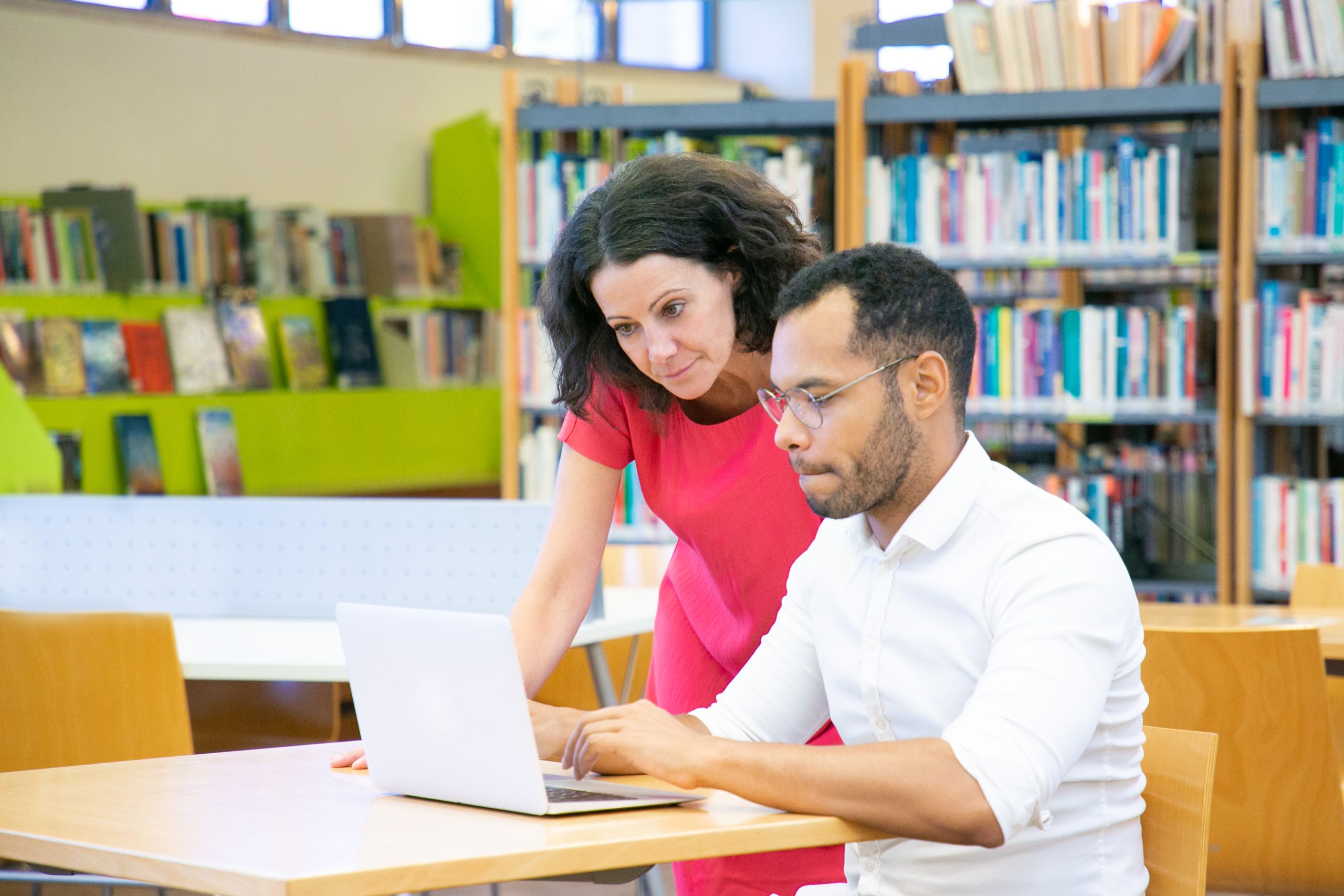 A focused student studying for the UGC NET exam with books and a laptop, highlighting dedication to academic preparation.